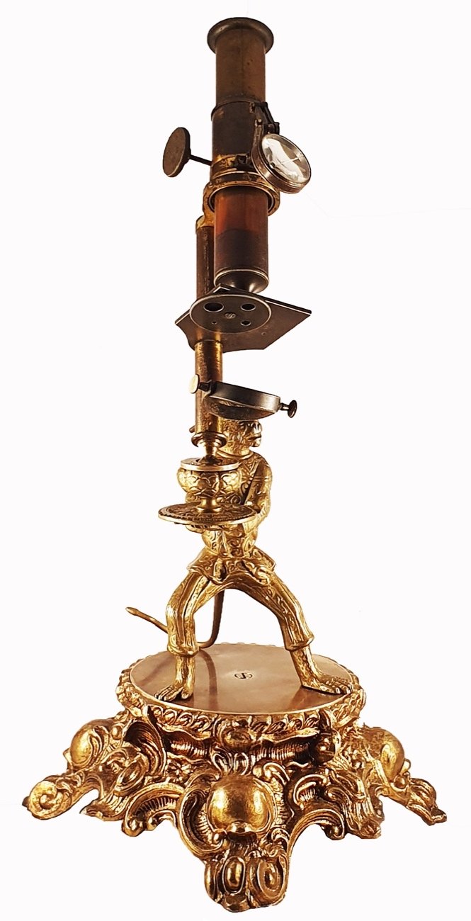 Microscope Statue A gold statue with a candle holderDescription automatically generated