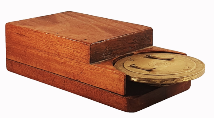 A wooden box with a gold lid
Description automatically generated
